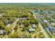 Wide aerial view showcasing a single-story home, lush greenery, a tranquil pond, and a peaceful residential area at 15765 Sunflower Trl, Orlando, FL 32828