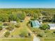 An aerial view displays the property's location with mature trees, lush landscapes and various buildings at 15765 Sunflower Trl, Orlando, FL 32828