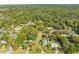 An aerial view displays the property's location with mature trees, lush landscapes and neighborhood at 15765 Sunflower Trl, Orlando, FL 32828