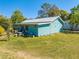 Exterior shot of the home with metal roof, wood siding and well-manicured lawn at 15765 Sunflower Trl, Orlando, FL 32828