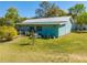 Exterior shot of the home with metal roof, wood siding and well-manicured lawn at 15765 Sunflower Trl, Orlando, FL 32828