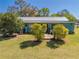 Single-story home featuring a metal roof, quaint wooden walkway, and lush green lawn with mature trees at 15765 Sunflower Trl, Orlando, FL 32828