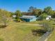 Single-story home with metal roof, green yard, and mature trees, set in a peaceful, spacious landscape at 15765 Sunflower Trl, Orlando, FL 32828