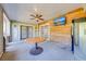 Relaxing sun room with a wood accent wall, ceiling fan, and access to the backyard at 15765 Sunflower Trl, Orlando, FL 32828