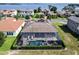 Aerial view of the property showcasing a screened pool, patio, manicured hedges, and a lake backdrop at 16736 Broadwater Ave, Winter Garden, FL 34787