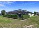 View of an enclosed lanai with a lush green hedge surrounding the patio and dining set at 16736 Broadwater Ave, Winter Garden, FL 34787