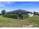 Backyard with a screened-in patio and privacy hedges, creating a secluded outdoor space at 16736 Broadwater Ave, Winter Garden, FL 34787