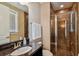 Bathroom shower with glass door and dark tile, along with a granite countertop sink at 16736 Broadwater Ave, Winter Garden, FL 34787