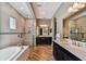 Luxurious bathroom with soaking tub, dual sinks, spacious shower, and wood-look tile flooring at 16736 Broadwater Ave, Winter Garden, FL 34787