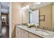 Bathroom with double sinks, granite countertops, a large mirror, and hardwood floors at 16736 Broadwater Ave, Winter Garden, FL 34787