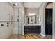 Elegant bathroom featuring an open walk-in shower with bench, double sink vanity, and wood tile floors at 16736 Broadwater Ave, Winter Garden, FL 34787