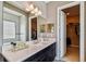 Bathroom featuring a double sink vanity, with marble countertops and a view of the walk-in closet at 16736 Broadwater Ave, Winter Garden, FL 34787