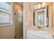 Bathroom shower with glass door, tan tile, and a white granite countertop sink at 16736 Broadwater Ave, Winter Garden, FL 34787