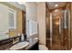 Bathroom featuring a glass shower with brown tile surround, a granite vanity, and white towels at 16736 Broadwater Ave, Winter Garden, FL 34787