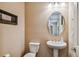 Half bathroom with pedestal sink, an oval mirror, and framed art at 16736 Broadwater Ave, Winter Garden, FL 34787