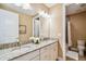 Bathroom with double sinks, granite countertops, and a large mirror with vanity lighting at 16736 Broadwater Ave, Winter Garden, FL 34787