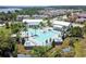 Aerial view of a luxurious community pool area with palm trees, lounge chairs, and elegant architectural design at 16736 Broadwater Ave, Winter Garden, FL 34787