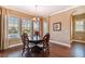 Bright dining room with wood floors, stylish chandelier, and three windows overlooking the yard at 16736 Broadwater Ave, Winter Garden, FL 34787
