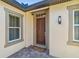 Welcoming front entrance with a wood door, exterior lighting, and a 'welcome' mat at 16736 Broadwater Ave, Winter Garden, FL 34787