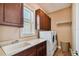 Functional laundry room featuring a sink, counter space, washer, dryer, and dark cabinets at 16736 Broadwater Ave, Winter Garden, FL 34787