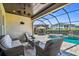 Covered patio featuring comfortable wicker furniture with a view of the pool and manicured landscaping at 16736 Broadwater Ave, Winter Garden, FL 34787