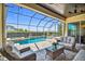 Covered patio featuring wicker furniture, a pool, a spa, and beautifully landscaped backyard at 16736 Broadwater Ave, Winter Garden, FL 34787