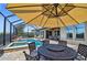 Outdoor seating area with large umbrella near the screened pool and water feature at 16736 Broadwater Ave, Winter Garden, FL 34787