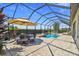 The screened pool area includes a dining set, sun umbrella and mature landscaping for privacy at 16736 Broadwater Ave, Winter Garden, FL 34787