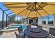 Screened-in pool area with table and chairs under an umbrella, and a view of the outdoor lounge area at 16736 Broadwater Ave, Winter Garden, FL 34787