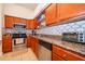 This is a well-lit kitchen featuring stainless steel appliances, granite countertops, and wooden cabinets at 204 David Walker Dr # A-4, Tavares, FL 32778