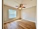 Bedroom with wood floors, a ceiling fan, and a window with blinds that lets in sunlight at 2073 Newtown Rd, Groveland, FL 34736