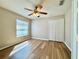 Bedroom with wood floors, a window with blinds and a closet, offering a comfortable living space at 2073 Newtown Rd, Groveland, FL 34736