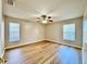 Bedroom with wood floors, a ceiling fan and two windows that allow for natural light at 2073 Newtown Rd, Groveland, FL 34736