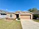 Charming single-story home with a well-maintained lawn and a two-car garage at 2073 Newtown Rd, Groveland, FL 34736