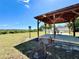 Gazebo with charcoal grill and picnic table overlooking an open grassy field and neighborhood play area at 2073 Newtown Rd, Groveland, FL 34736