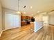 Bright kitchen featuring wood floors, cabinets and a breakfast bar leading to the dining area at 2073 Newtown Rd, Groveland, FL 34736