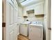 This utility room features white cabinets and includes a newer model washer and dryer at 2073 Newtown Rd, Groveland, FL 34736