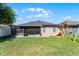 Spacious backyard featuring a lush lawn, screened patio, and a play structure at 2258 Crystal Falls Way, Orlando, FL 32824