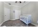 Bedroom with white crib, wood-look flooring, closet, and a door, offering a serene and functional space at 2258 Crystal Falls Way, Orlando, FL 32824