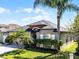 Well-maintained home showcasing a lush green lawn, palm trees, and manicured hedges enhancing its curb appeal at 2258 Crystal Falls Way, Orlando, FL 32824