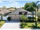 Charming single-story home featuring a well-manicured lawn, mature palm trees, and a two-car garage on a sunny day at 2258 Crystal Falls Way, Orlando, FL 32824