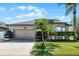 Inviting home with a manicured lawn, mature palm trees, and a two-car garage on a sunny day at 2258 Crystal Falls Way, Orlando, FL 32824