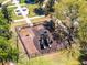 Aerial shot of a fenced playground with slides and benches, nestled in a park with picnic tables and mature trees at 2258 Crystal Falls Way, Orlando, FL 32824