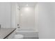 Well-lit bathroom featuring a bathtub with white tile surround and a vanity with gray countertop at 2306 Lancashire St, Davenport, FL 33896