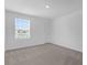 Bedroom with neutral carpet, white walls, a window with blinds, and an interior door at 2306 Lancashire St, Davenport, FL 33896