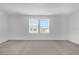 Bright bedroom featuring neutral carpet, white walls, and natural light from the double window at 2306 Lancashire St, Davenport, FL 33896