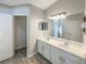 Bathroom with double sink vanity, framed mirrors, modern fixtures, and hard surface flooring at 2350 Blue Sapphire Cir, Orlando, FL 32837