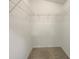 An empty walk-in closet with wire shelving and neutral carpeting offers ample storage space at 2350 Blue Sapphire Cir, Orlando, FL 32837