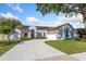 Charming single-story home features a well-manicured lawn, a concrete driveway, and solar panels for energy efficiency at 2821 Lone Feather Dr, Orlando, FL 32837