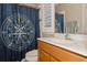 Bathroom with mystic shower curtain, single sink vanity, and white shutters on the window at 316 Trieste Loop, Lake Mary, FL 32746